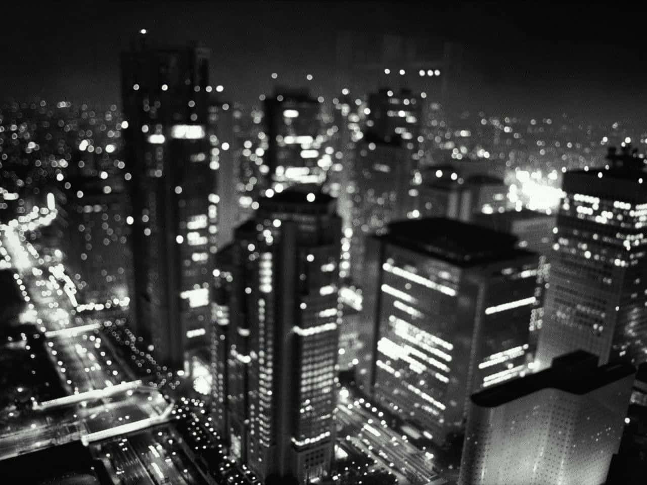 黑白夜景城市景觀，帶有模糊的燈光和高樓大廈。