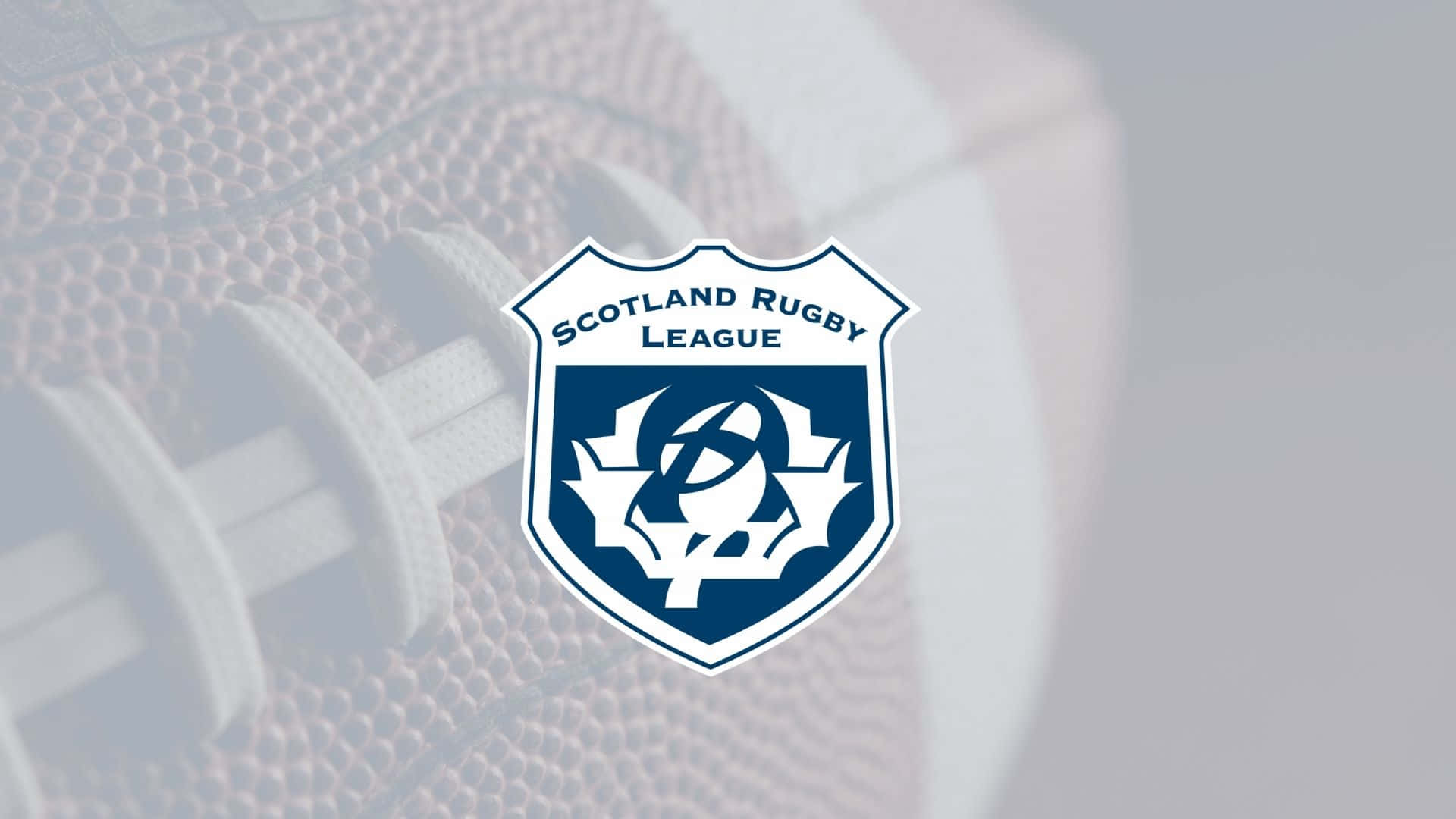 Scotland Rugby 桌布 壁紙 — 蘇格蘭欖球聯賽標誌居中於模糊的欖球背景上，帶有白色鞋帶和紋理皮革。