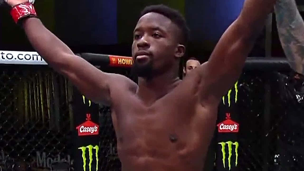 MMA 拳手在八角籠中高舉雙臂慶祝勝利。