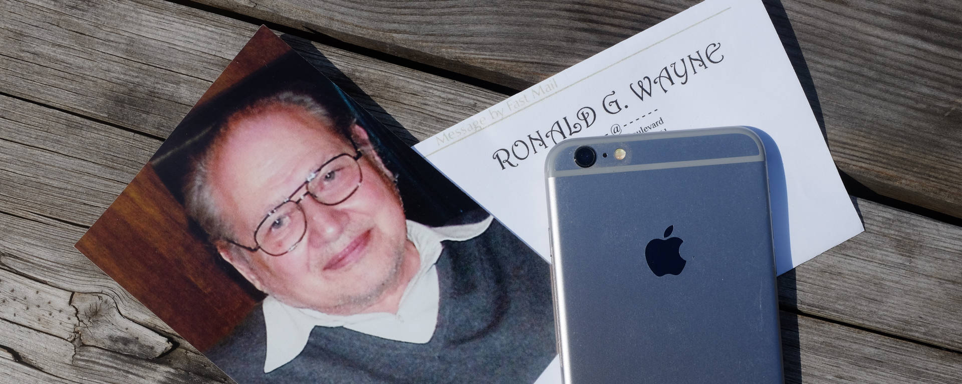 Ronald G Wayne 與 iPhone 在木質表面上的照片