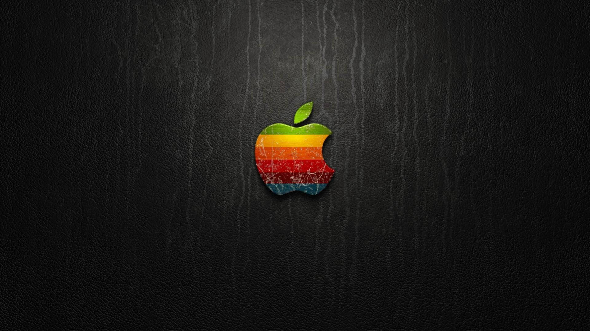 復古彩虹Apple標誌，帶有裂紋質感，深色皮革背景。