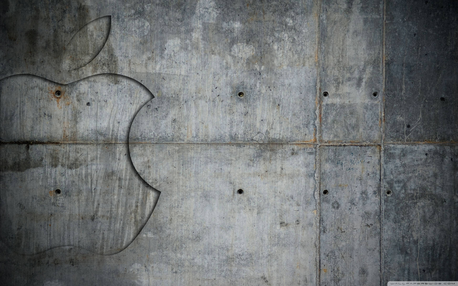 褪色的Apple標誌蝕刻在風化的混凝土牆上，帶有鏽跡和螺栓孔。