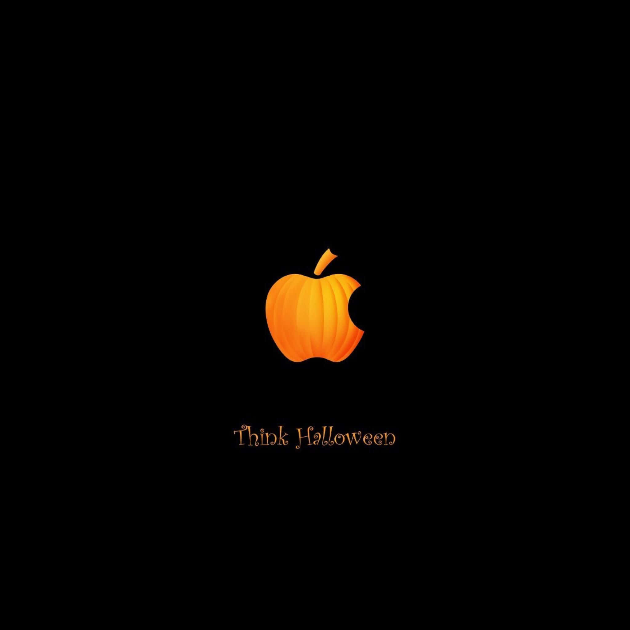 蘋果萬聖節壁紙 壁紙 — 一個發光的橙色南瓜取代了Apple標誌，背景為黑色，下方有「Think Halloween」文字。