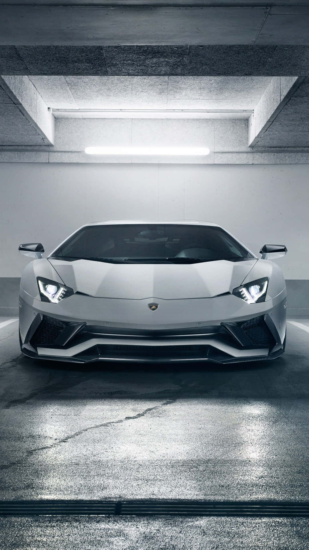 銀色林寶堅尼Aventador在混凝土車庫中，光管照明下。