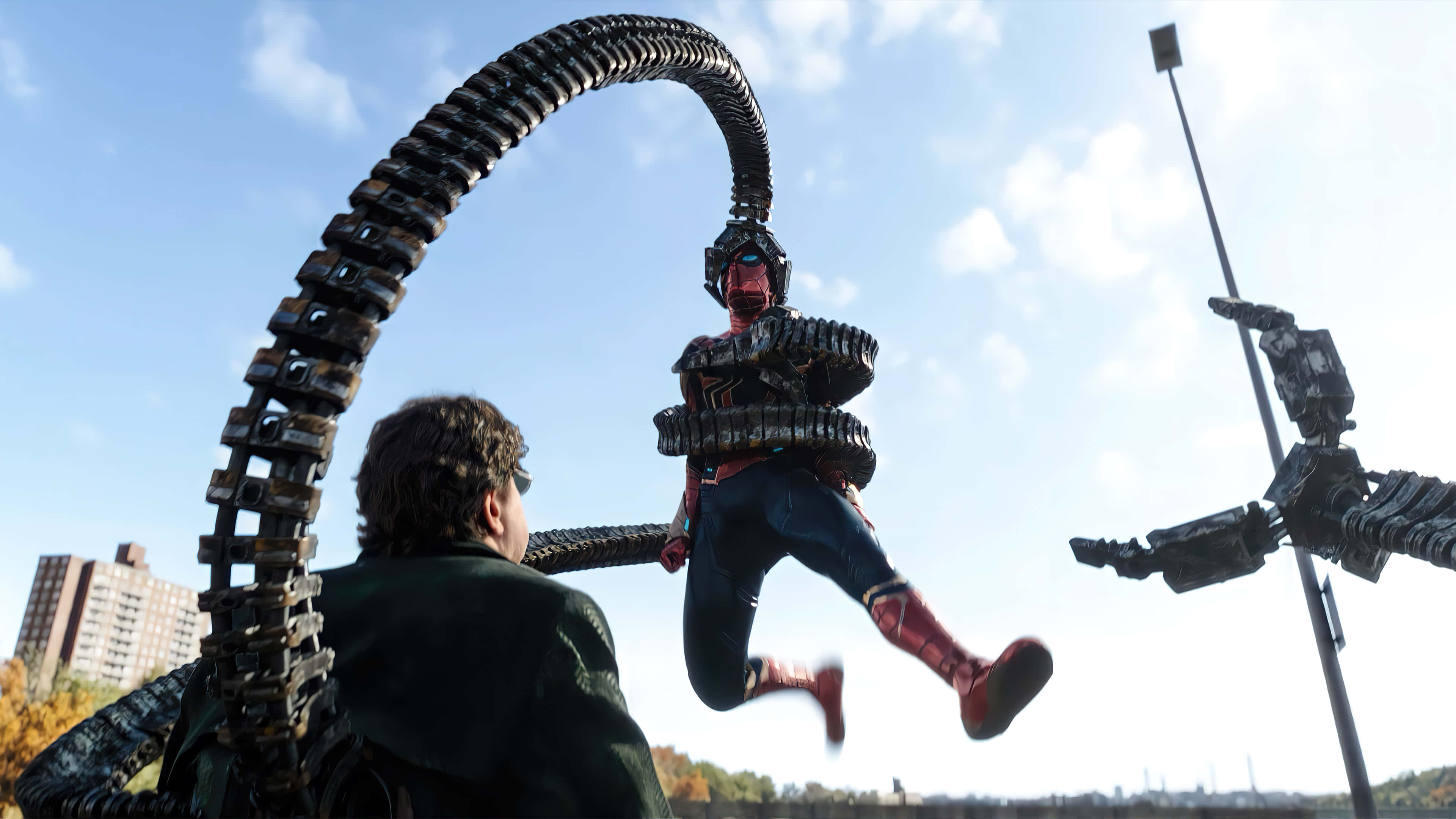 Spider Man No Way Home 桌布 壁紙 — 蜘蛛俠在都市景觀中擺盪，躲避機械觸手，同時一名男子從下方觀看。
