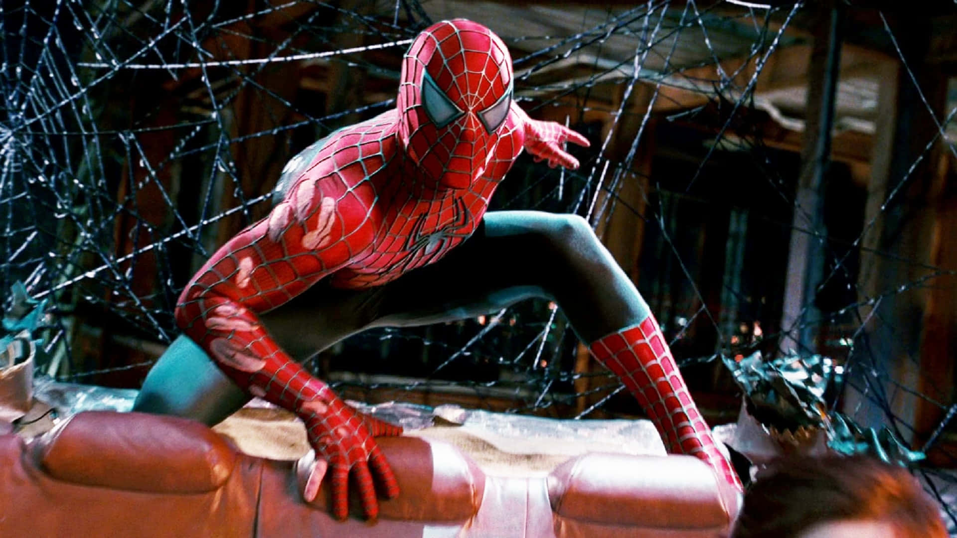 Spider Man 3 桌布 壁紙 — 蜘蛛俠蹲在破爛的皮梳化上，周圍是碎玻璃，房間光線昏暗。