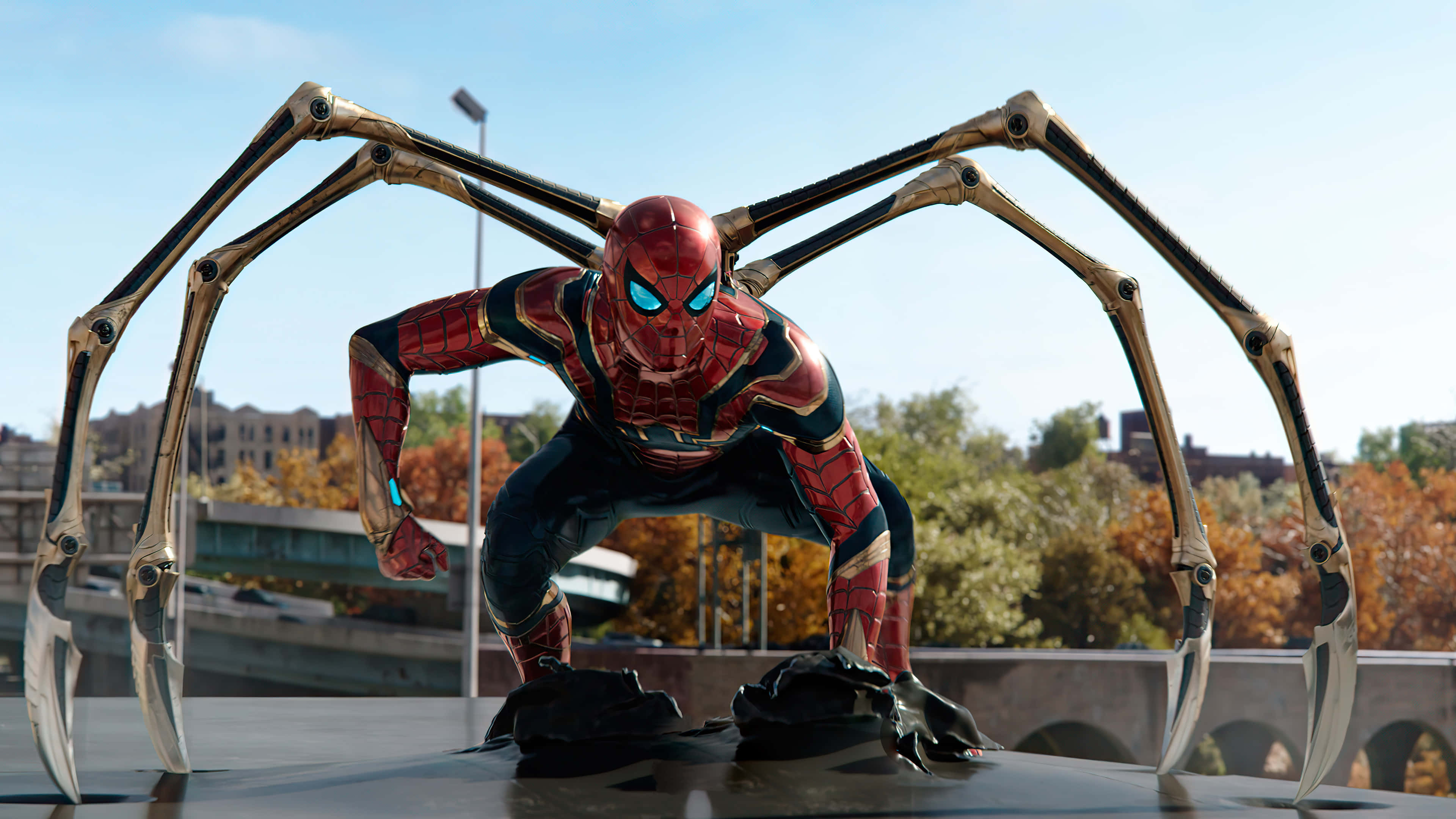 Spider Man No Way Home 桌布 壁紙 — 蜘蛛俠身穿紅金色裝甲戰衣蹲伏在橋上，機械蜘蛛腿伸展，背景是城市天際線。