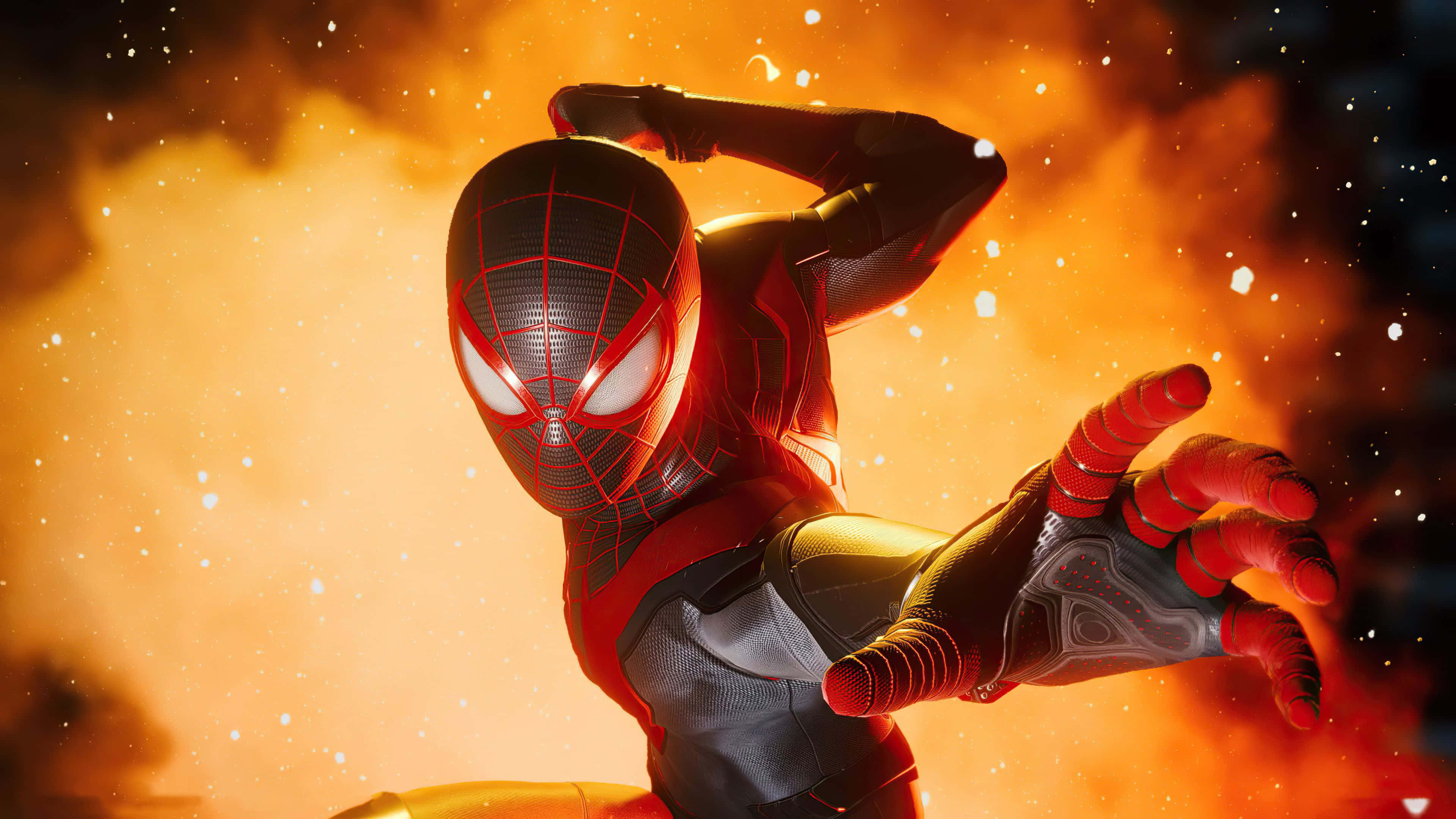 Miles Morales 動漫 桌布 壁紙 — 蜘蛛俠身穿紅黑戰衣，在熾熱的橙色爆炸背景下擺出動態姿勢。
