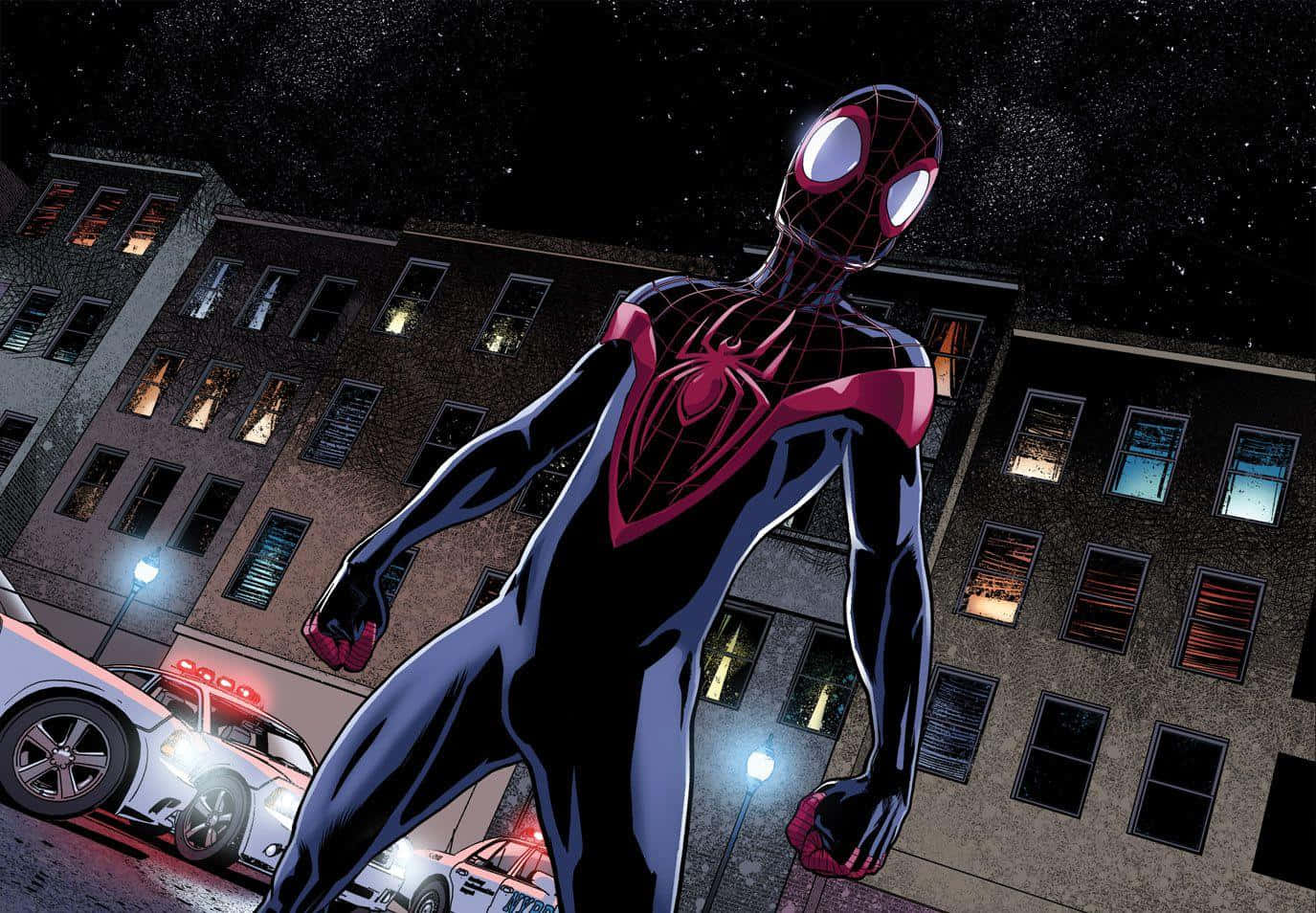 Miles Morales 動漫 桌布 壁紙 — 蜘蛛俠身穿黑色和粉紅色戰衣，在星空下英雄般地站在城市街道上，身後有警車和亮著的窗戶。