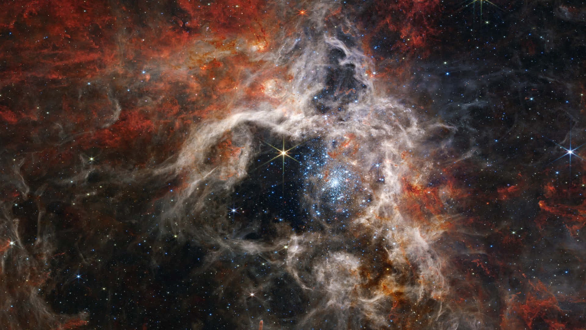 蜘蛛星雲天文 壁紙 — 一個宇宙星雲在佈滿星星的黑色虛空中旋轉，呈現火紅和發光的白色。