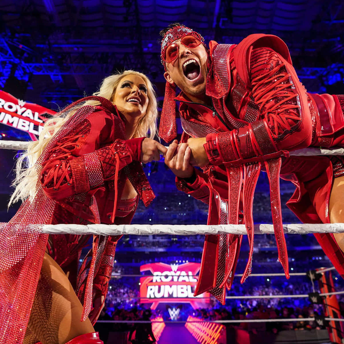 WWE摔角手穿著紅色服裝在皇家大戰活動期間在擂台上慶祝。