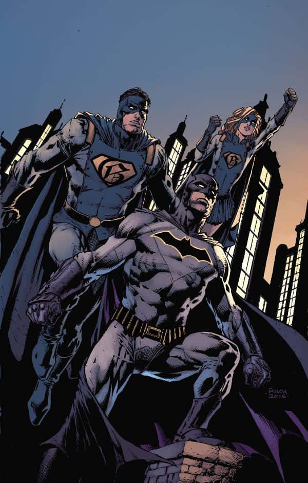 Batman Reborn 桌布 壁紙 — 蝙蝠俠、超人和超級少女英勇地站在屋頂上，背景是暮色中的城市天際線，帶有戲劇性的燈光。