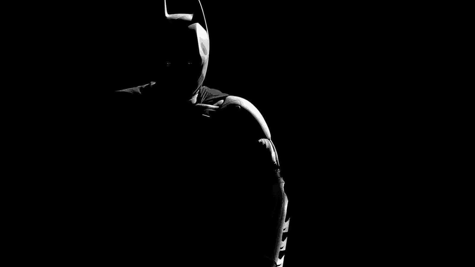 Shadow Of The Bat 桌布 壁紙 — 蝙蝠俠以陰影剪影站在黑色背景前，戲劇性的側光照亮了他的頭罩和裝甲肩膀。