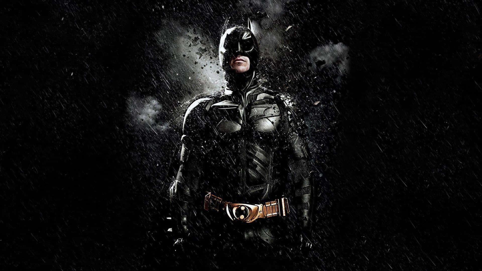 Batman Desktop 桌布 壁紙 — 蝙蝠俠在雨中的高譚之夜堅定站立，他的裝甲服在戲劇性燈光下閃耀，碎片在他周圍旋轉。