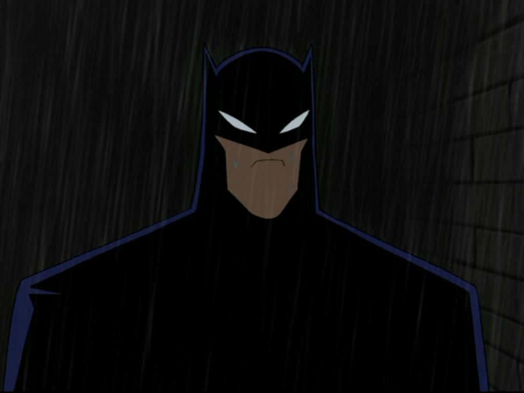 The Batman Vs Dracula 桌布 壁紙 — 蝙蝠俠在雨中莊嚴地站立，眼睛發光，背景是深色磚牆。
