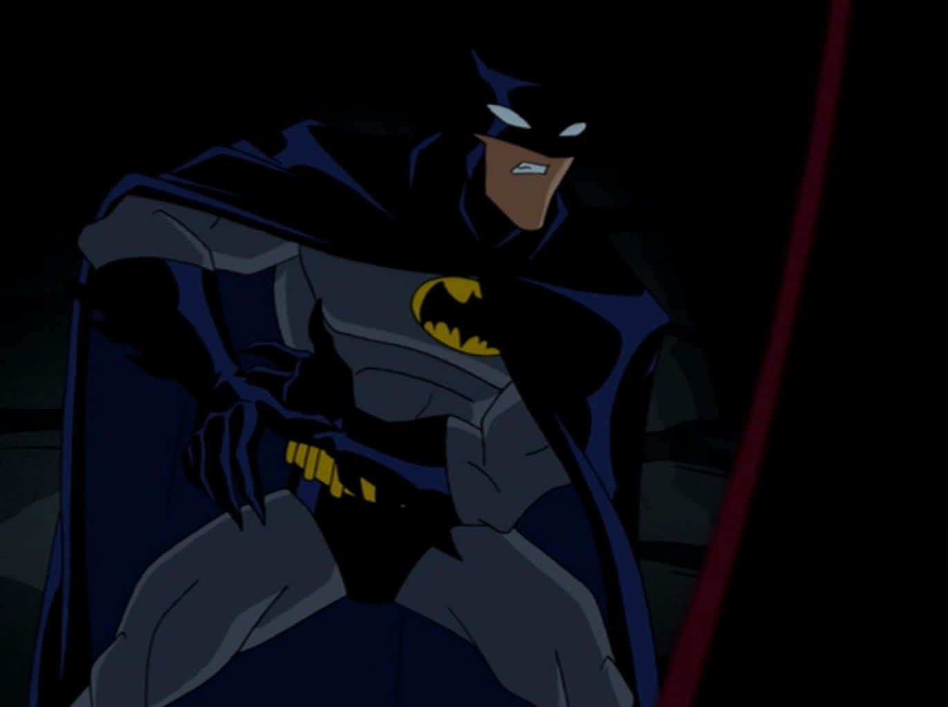 The Batman Vs Dracula 桌布 壁紙 — 蝙蝠俠站在陰影黑暗中，雙眼發光，表情堅定，身穿標誌性戰衣。