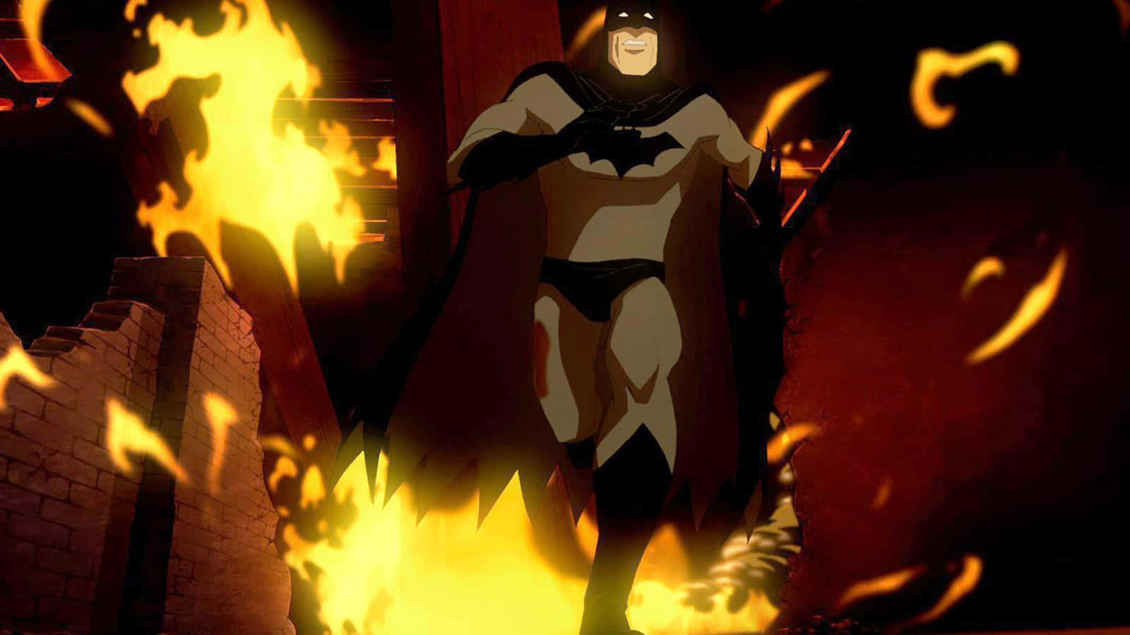 Batman Year One 桌布 壁紙 — 蝙蝠俠英勇地站在黑暗廢墟建築中咆哮的火焰裡，發光的餘燼在他周圍旋轉。