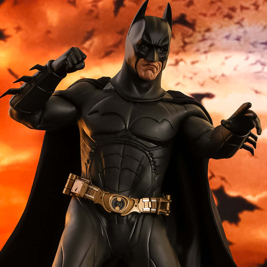 Batman Begins 桌布 壁紙 — 蝙蝠俠雕像屹立在火紅色的天空中，蝙蝠剪影在他周圍飛翔。