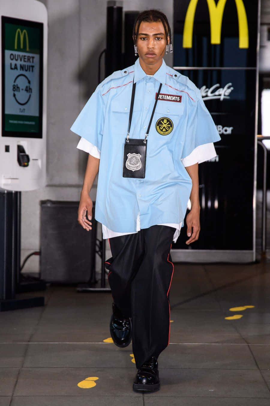 穿著麥當勞主題制服模特兒在夜間餐廳中行走。