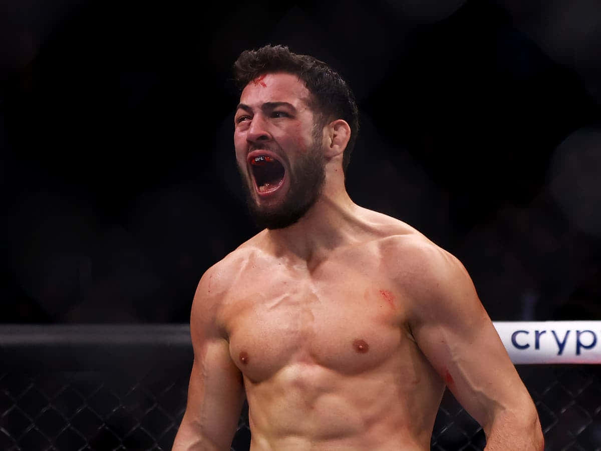 一名渾身是血的MMA拳手在黑暗的八角籠內發出勝利的咆哮。