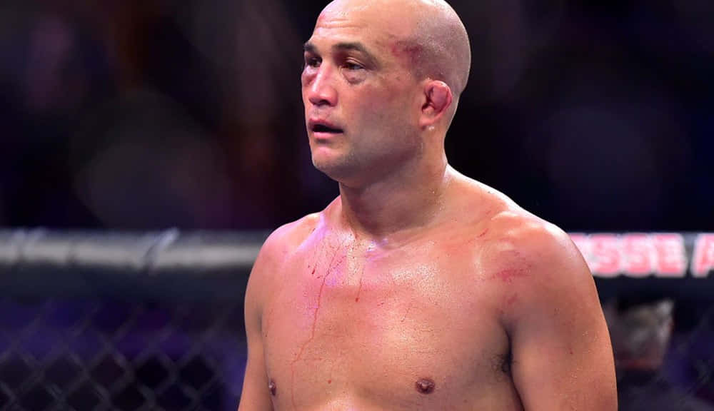 一名渾身是血的MMA選手在比賽後站在八角籠中。