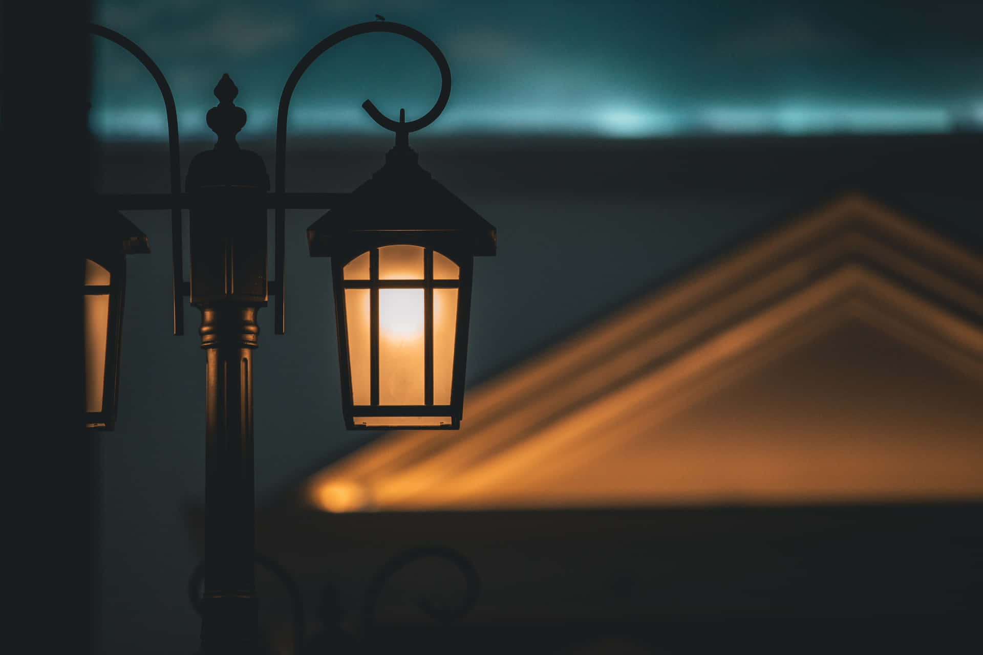 夜間發光的復古街燈，背景有模糊的建築物