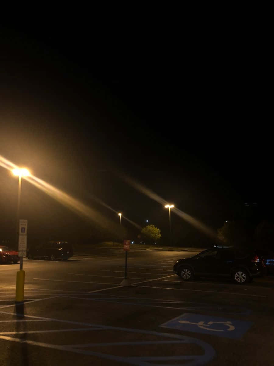 有霧條件下的夜間停車場，帶有街燈和停泊的汽車。