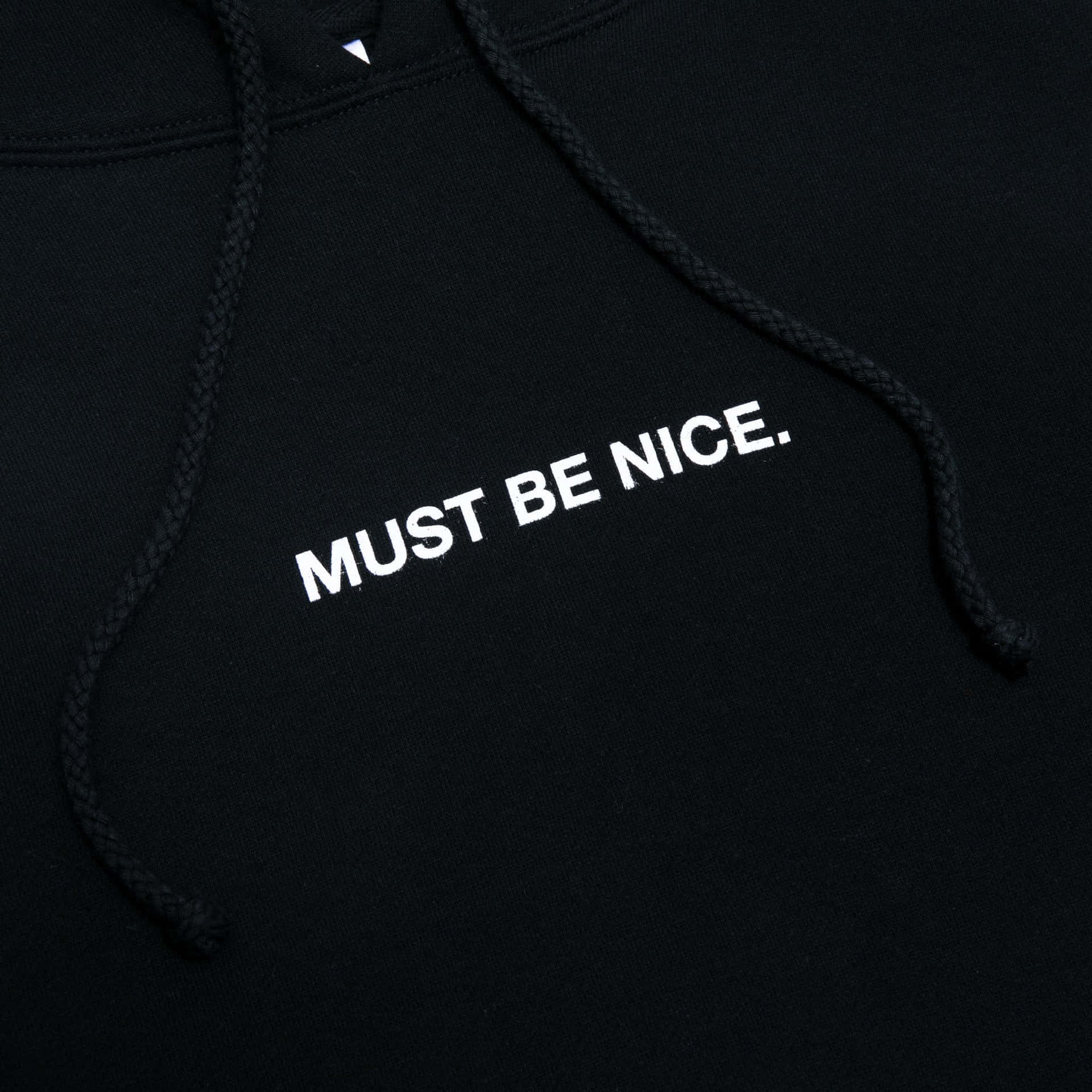 黑色連帽衛衣，白色刺繡文字寫著 MUST BE NICE。