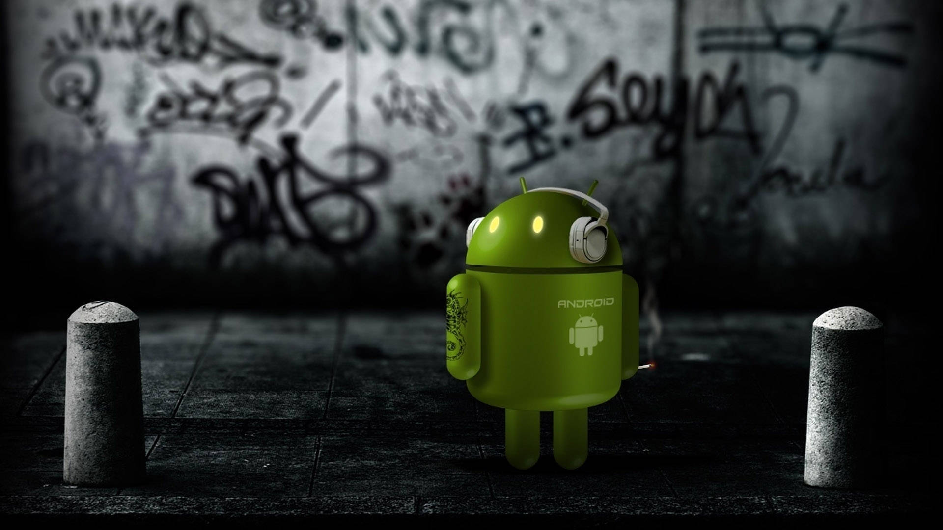 夜晚塗鴉小巷中的綠色Android吉祥物和混凝土護柱。