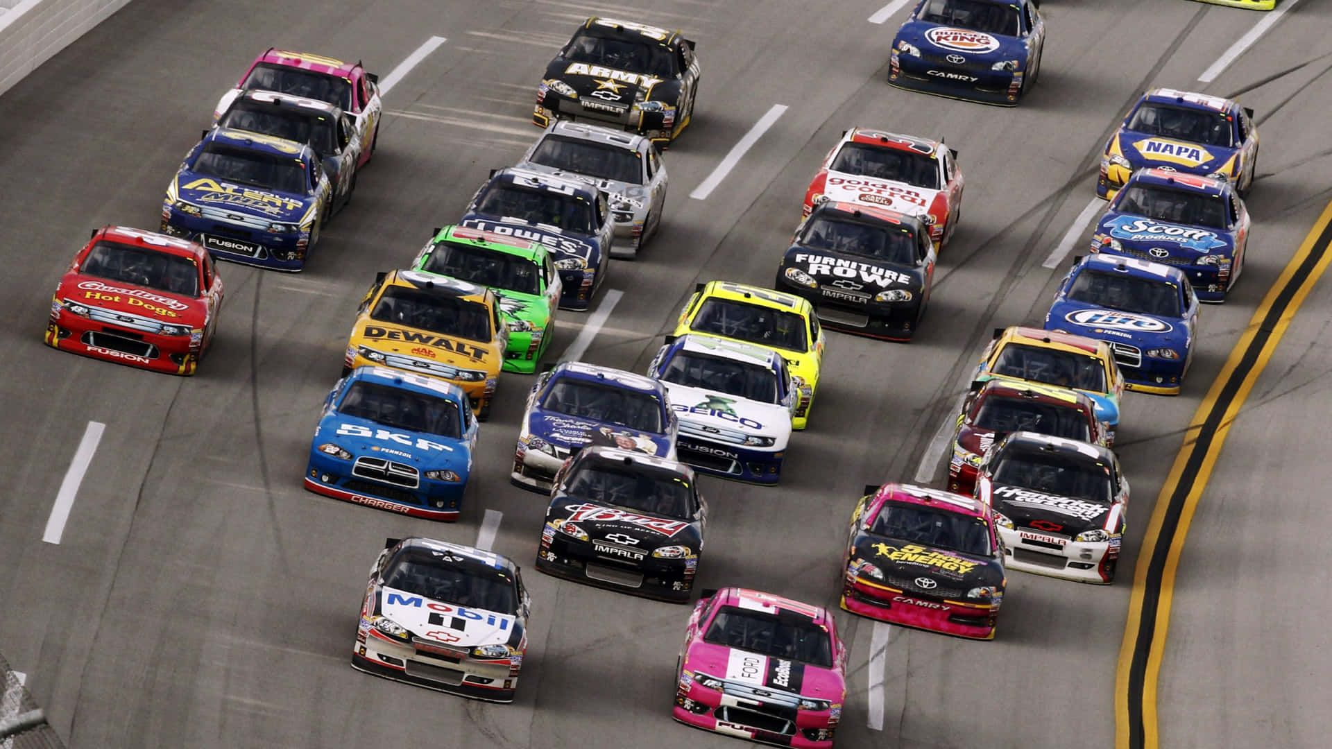 NASCAR賽車在夜間體育場燈光下繞著賽道疾馳。