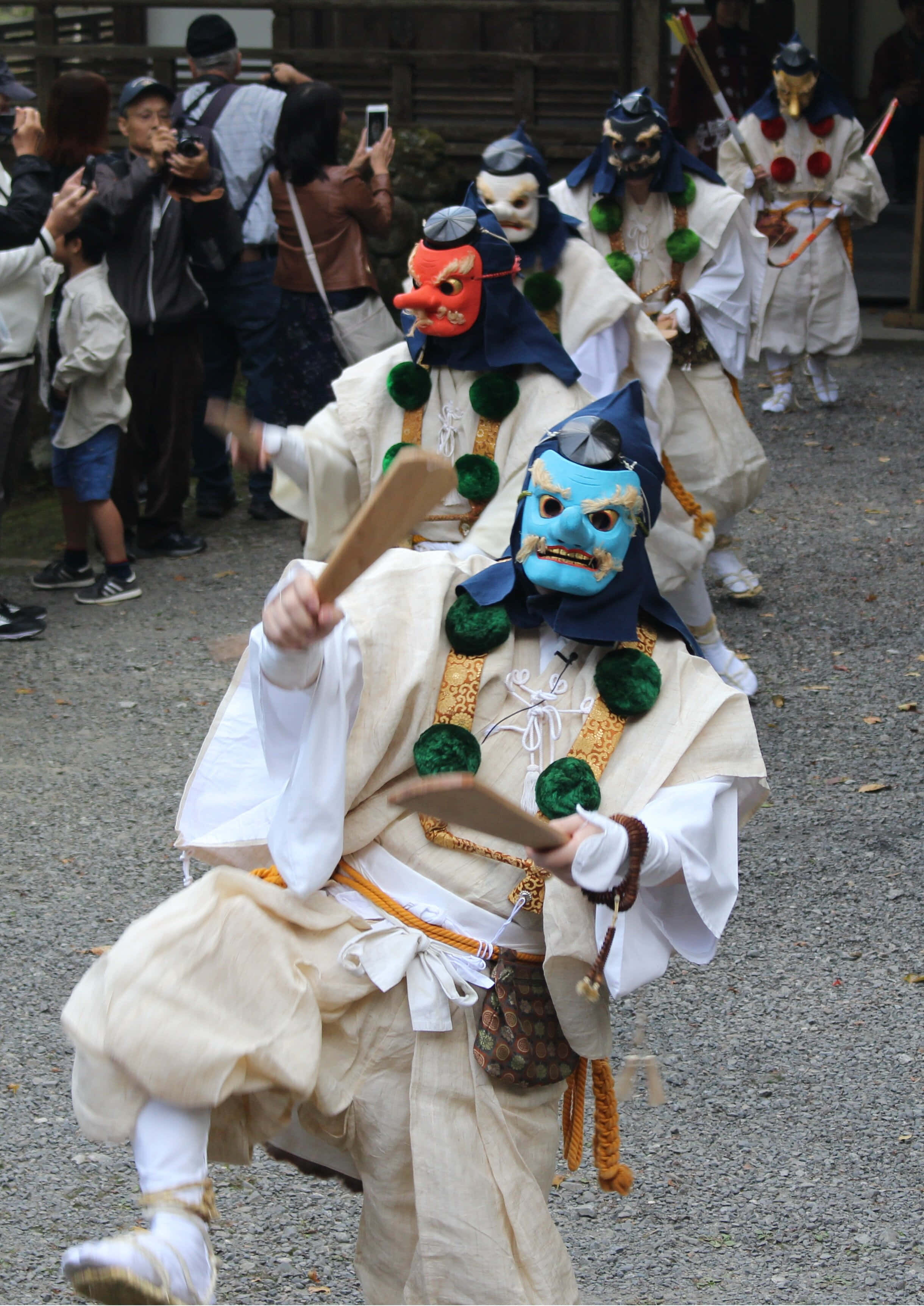 Tengu 桌布 壁紙 — 表演者戴著充滿活力的傳統面具和白色長袍，在文化節日期間充滿活力地跳舞。