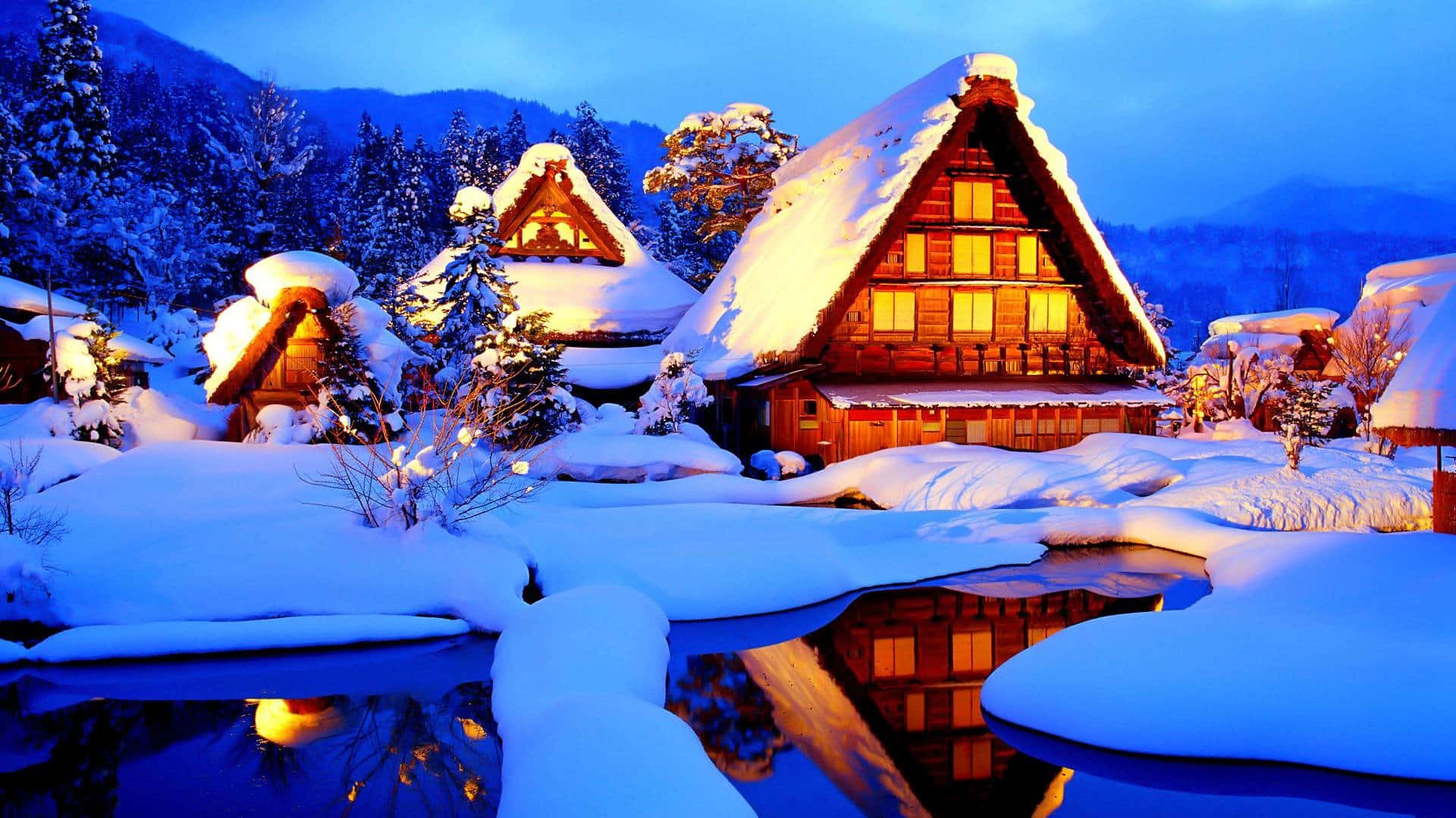 Cozy Winter Cabin 桌布 壁紙 — 被雪覆蓋的傳統日本房屋在結冰池塘中映照的暮色天空下溫暖地發光。