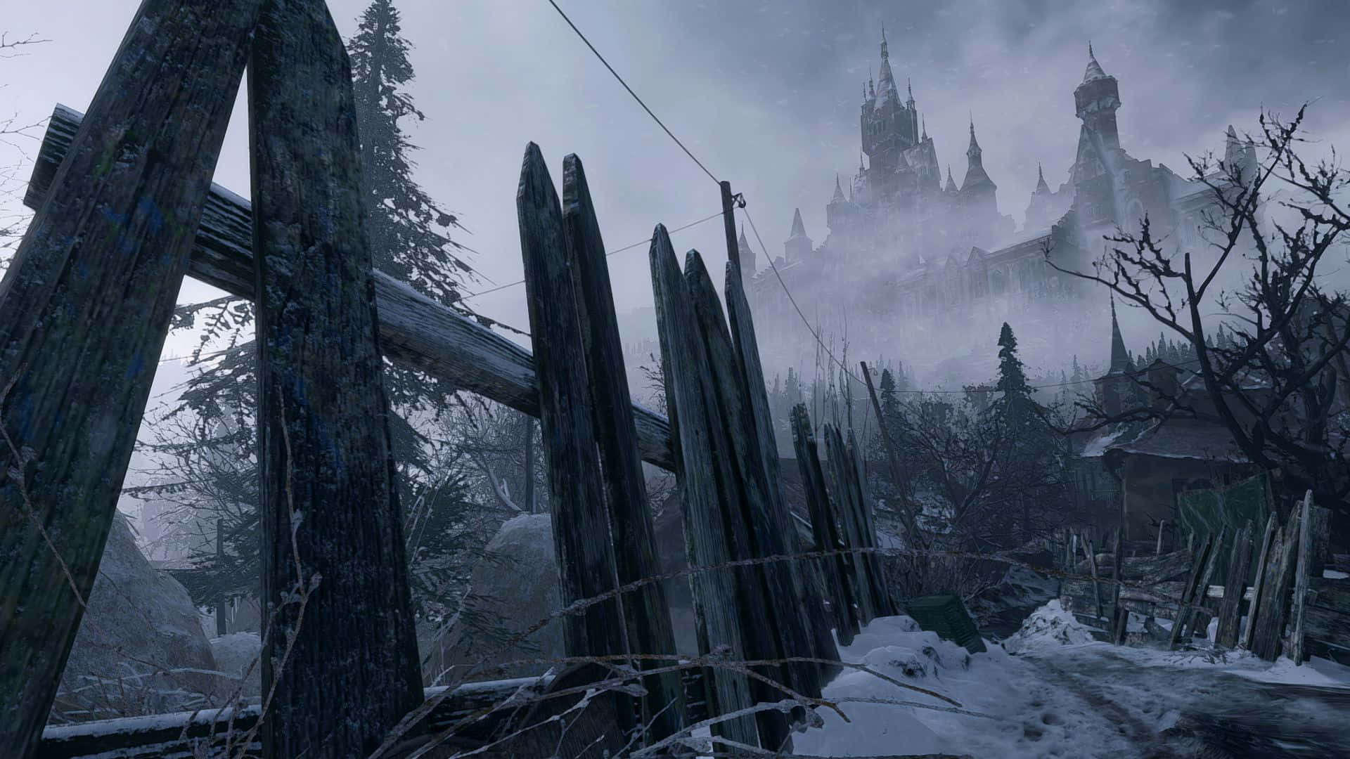 Resident Evil Village 桌布 壁紙 — 被雪覆蓋的木柵欄框住了遠處在陰沉冬日天空下籠罩在迷霧中的哥德式城堡。