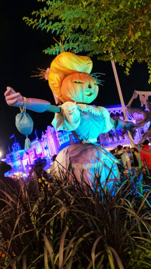 夜間萬聖節節日中，發光的傑克南瓜燈稻草人伴隨著彩色燈光。