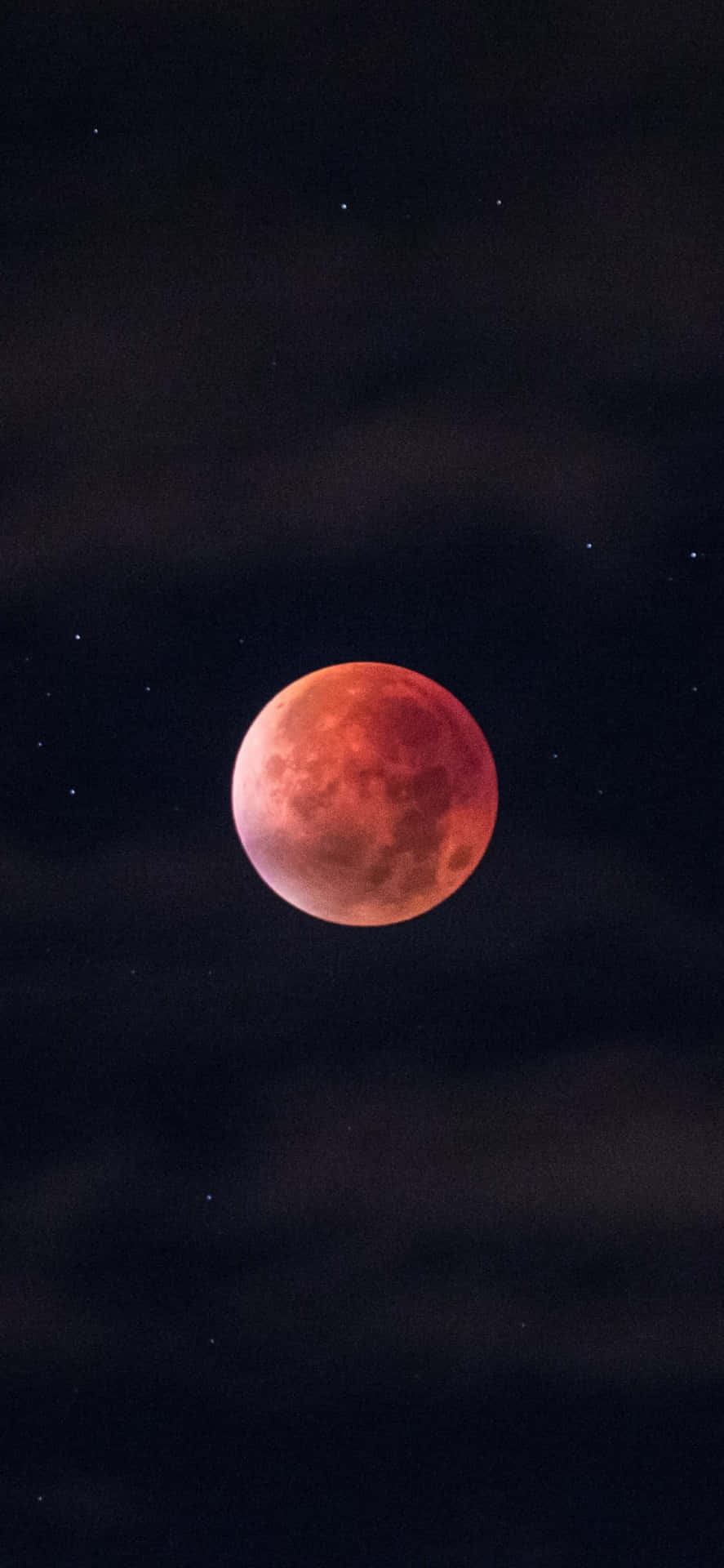 一輪紅色的血月在繁星點點的夜空中閃耀，伴隨著烏雲。