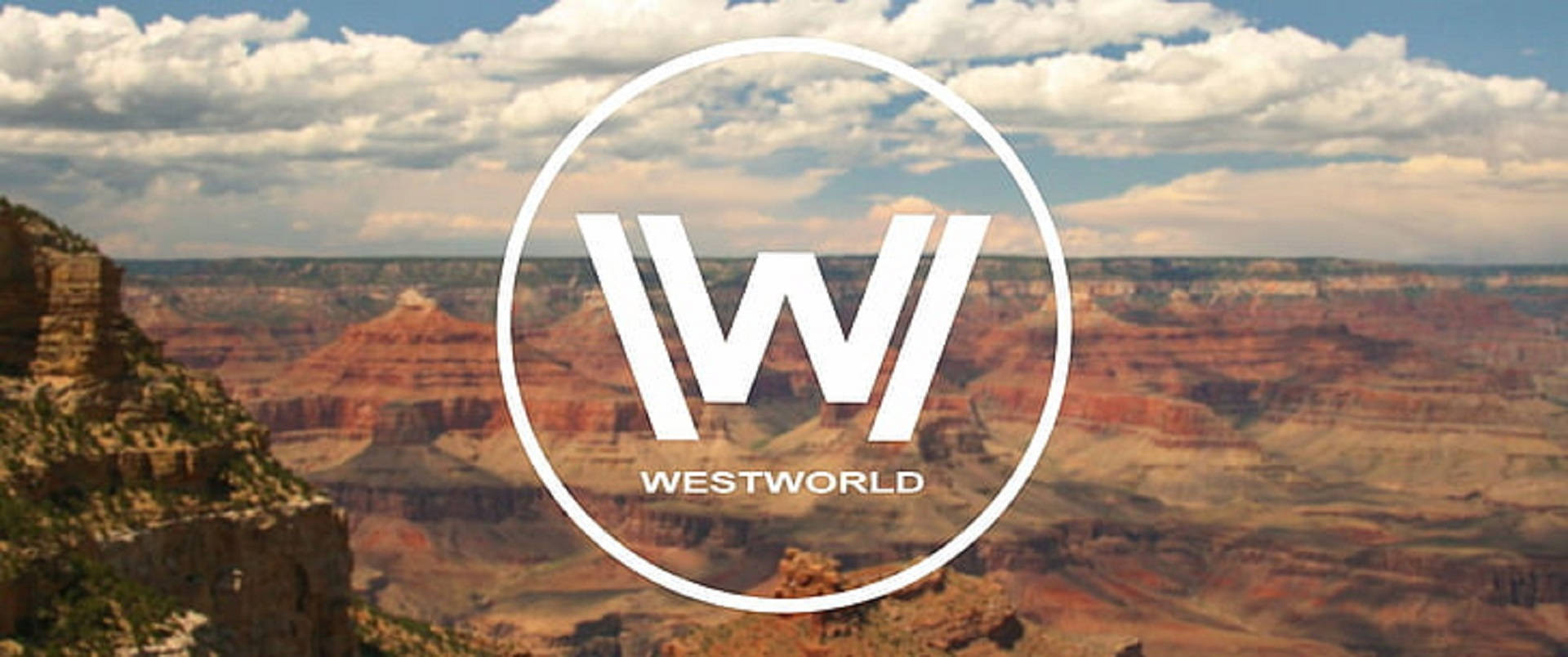 西世界標誌與山崖 壁紙 — 大峽谷景色上覆蓋著Westworld標誌，天空多雲。