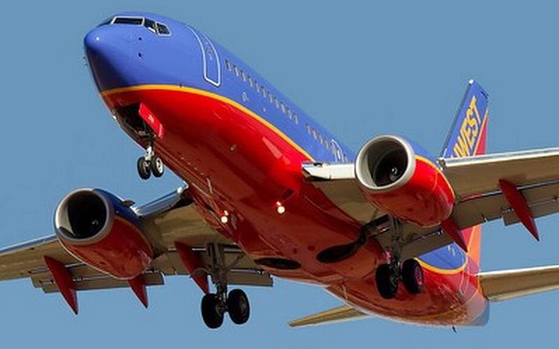 西南航空飛機在晴朗的藍天下放下起落架下降