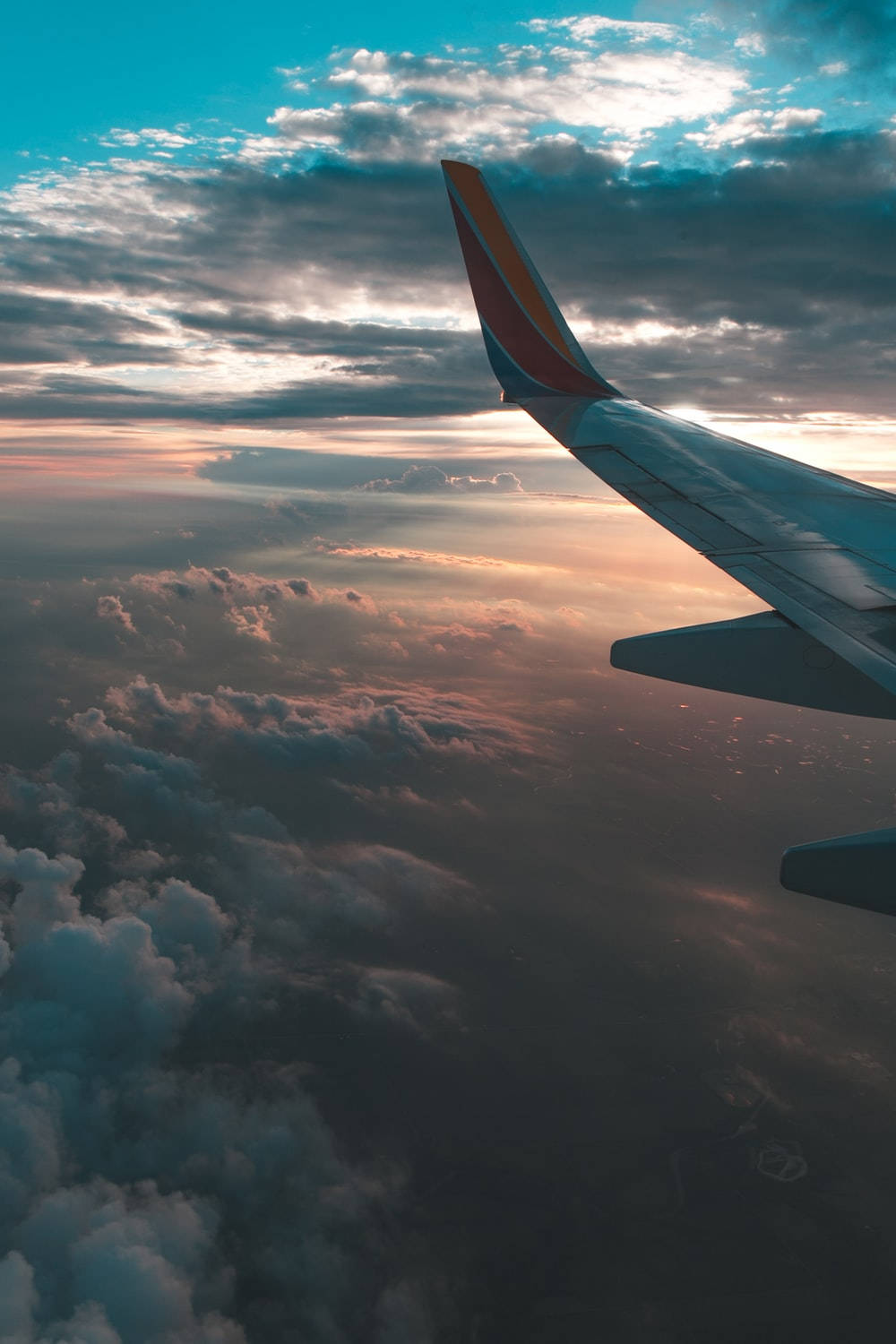 飛機機翼在夕陽雲層上方翱翔