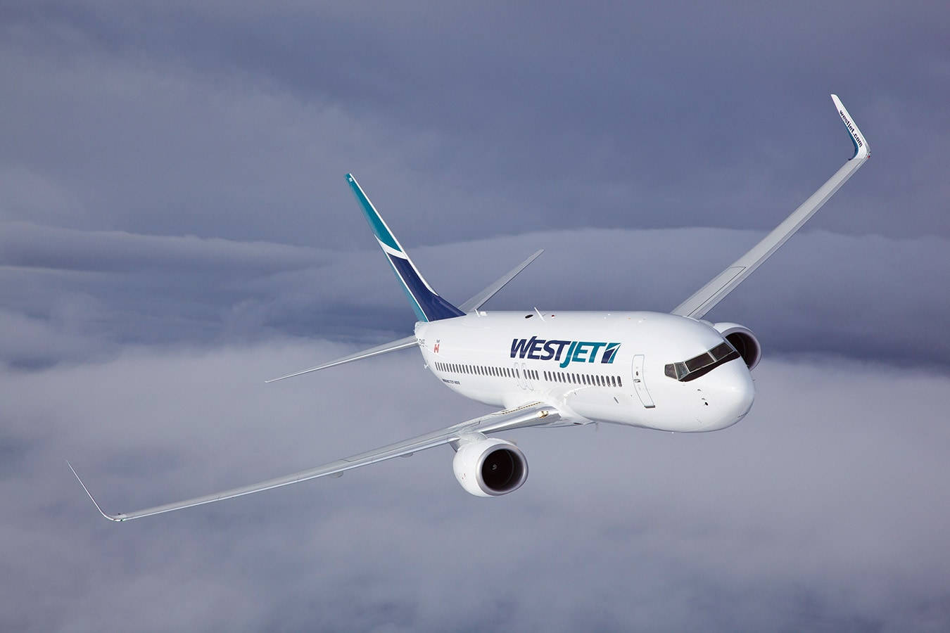西捷航空飛機在灰色雲層上方飛行