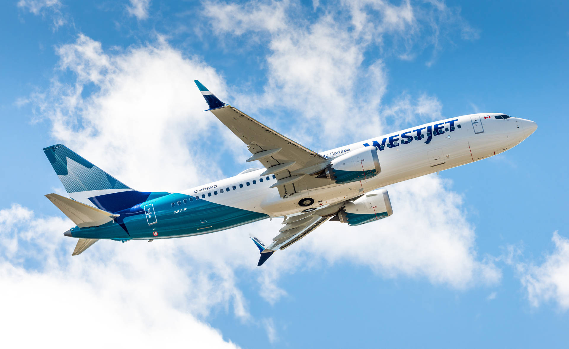 Vestjet飛機在藍天白雲中飛行。