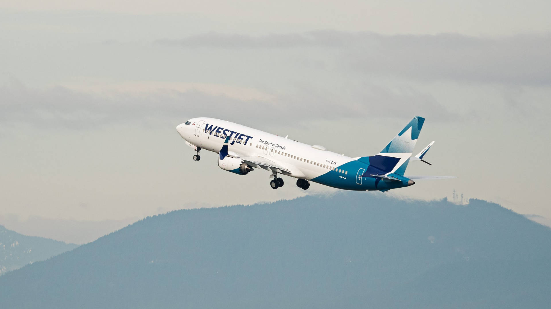 西捷航空飛機在山脈上空起飛