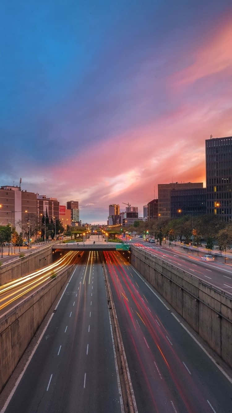 城市高速公路在黃昏時分，帶有車燈光軌和色彩繽紛的天空。