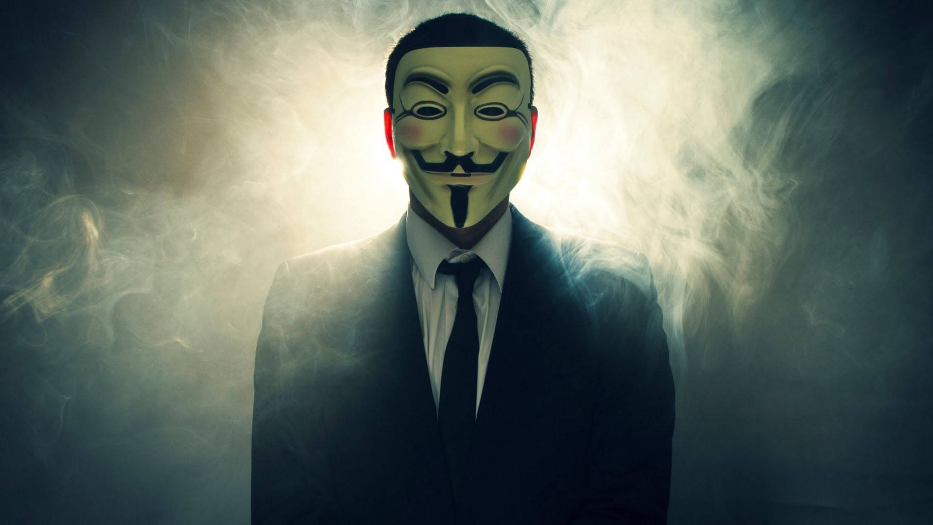 穿西裝的男子戴著綠色蓋伊·福克斯面具，被煙霧包圍。