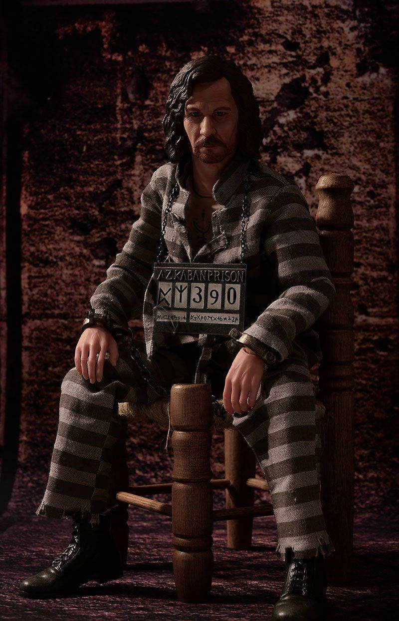 一名身穿條紋囚服的囚犯坐在木椅上，手持Azkaban Prison身份標籤。