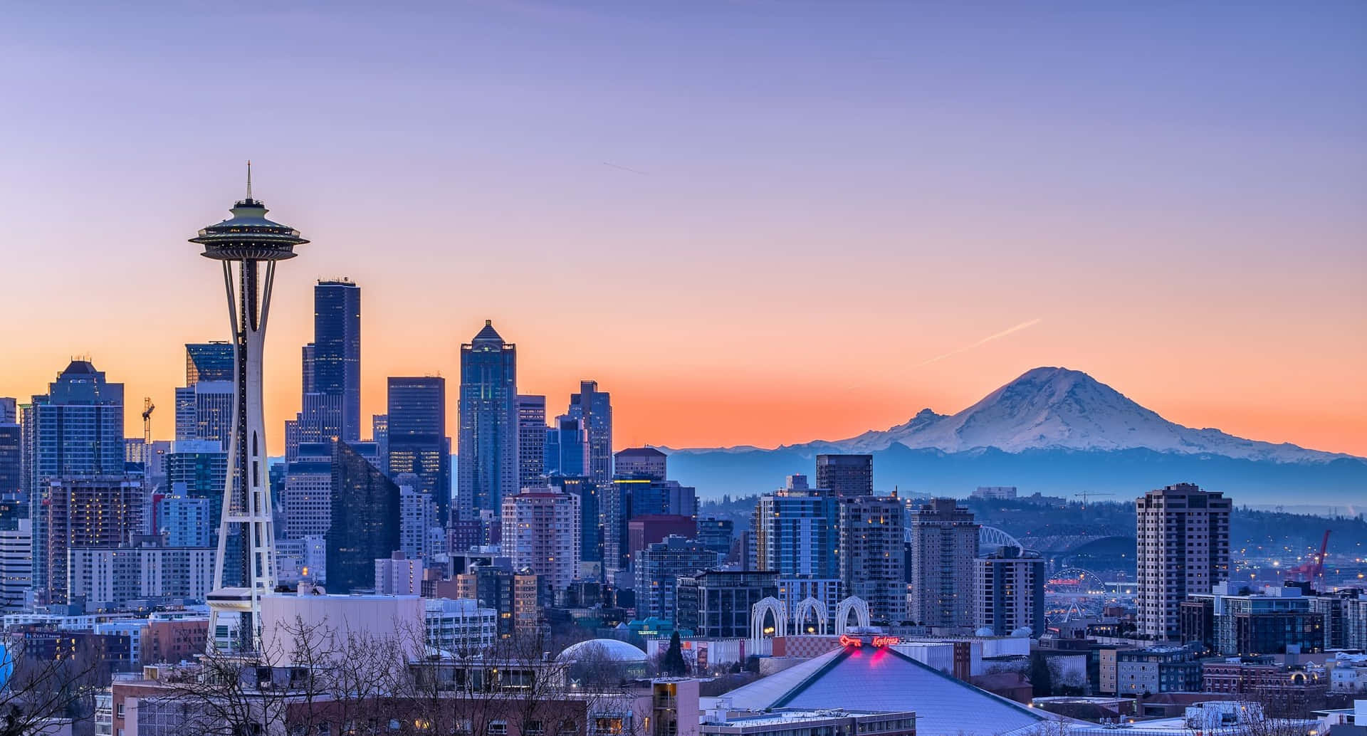 西雅圖日落時分城市景觀，可見太空針塔和雷尼爾山。