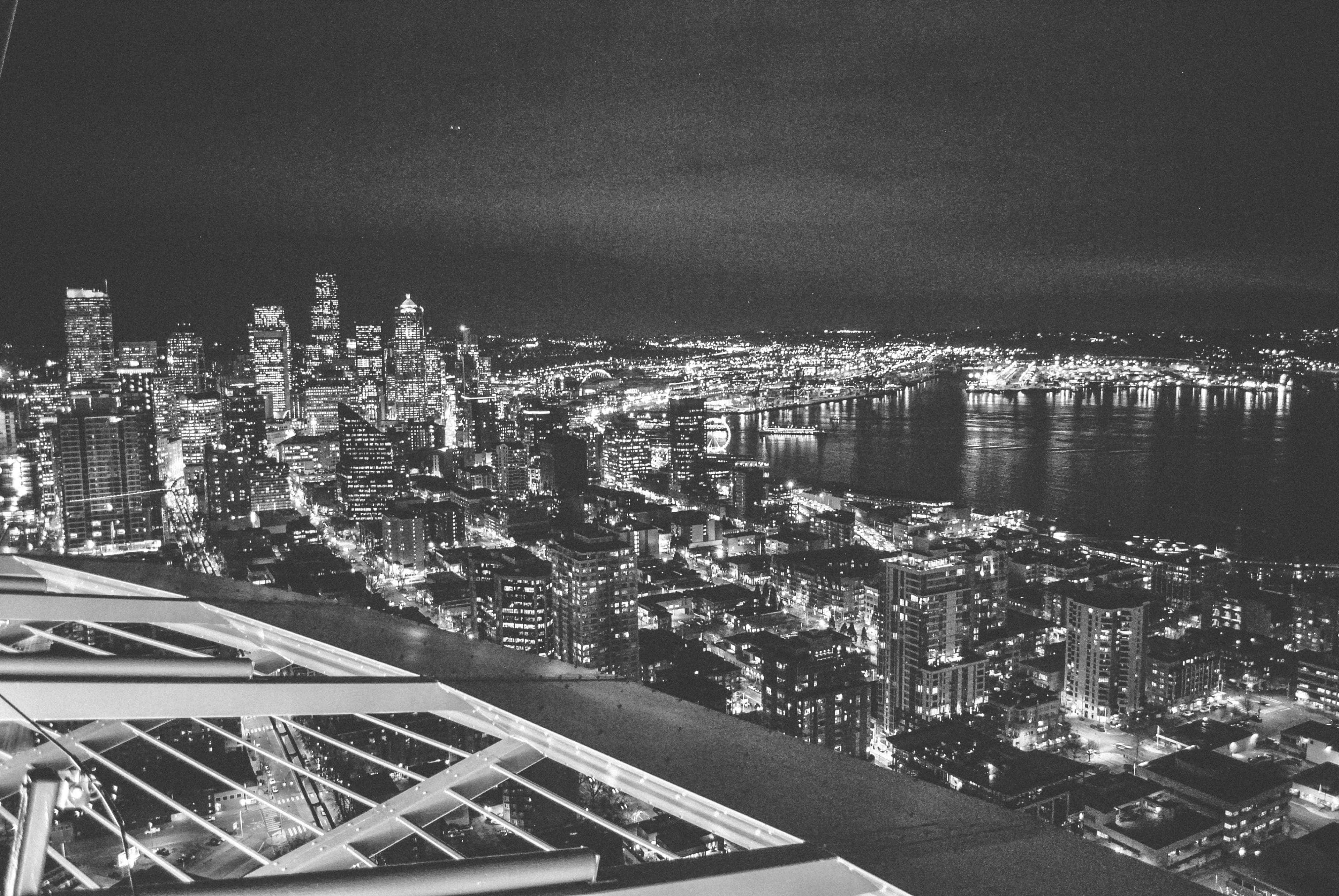 西雅圖夜景黑白照 壁紙 — 黑白夜間鳥瞰圖，展現廣闊的城市景觀，閃爍的摩天大樓和明亮的 waterfront。