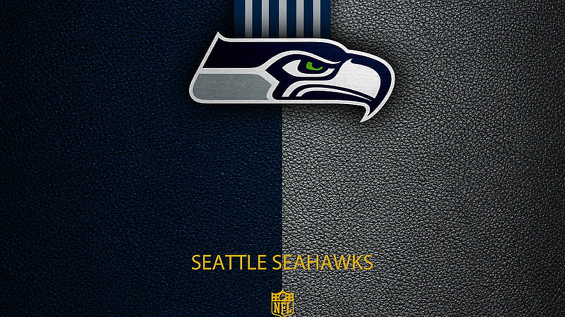 Seattle Seahawks 桌布 壁紙 — 西雅圖海鷹隊標誌，海軍藍和銀色，在紋理皮革背景上，下方有球隊名稱和NFL盾牌。