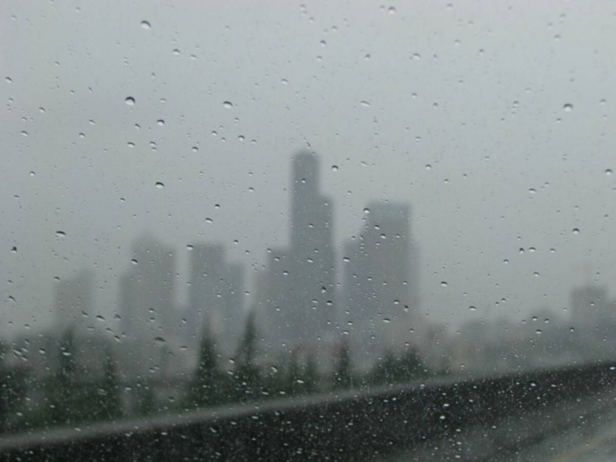 車窗上的雨點，背景是模糊的城市天際線。