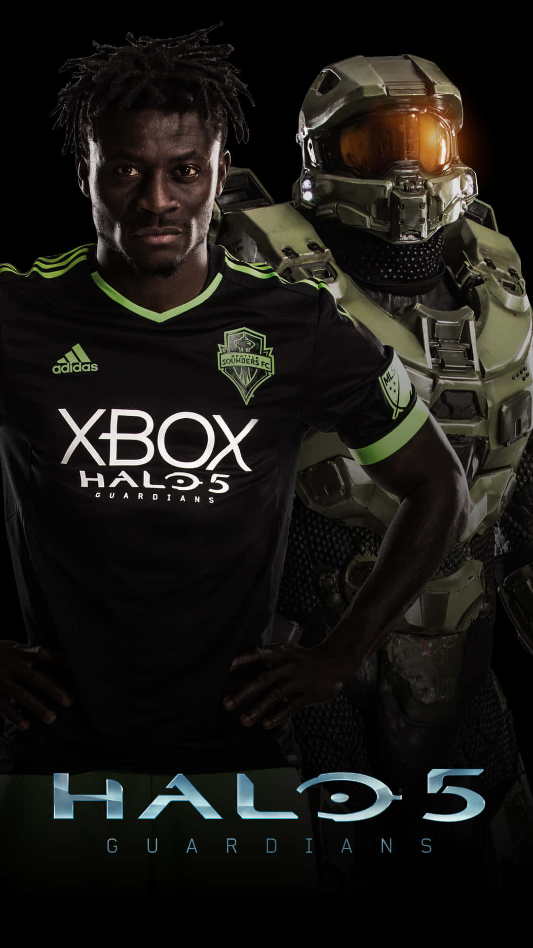 西雅圖音速隊 XBOX HALO 球衣 壁紙 — 一名穿著黑色Xbox Halo 5球衣的足球員站在發光橙色面罩的Halo 5 Spartan旁邊，背景為深色。