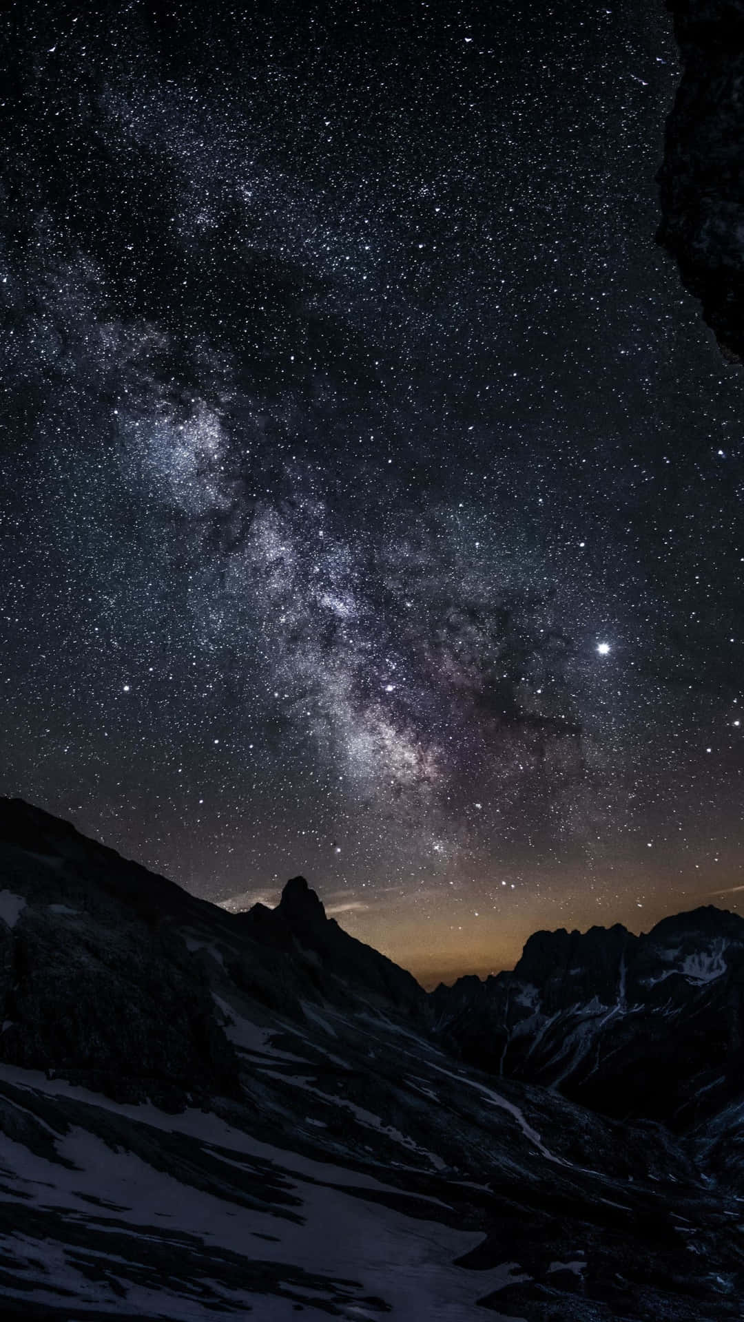 夜晚積雪的山峰上空的銀河系